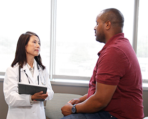 Hombre conversando con un proveedor de atención médica.